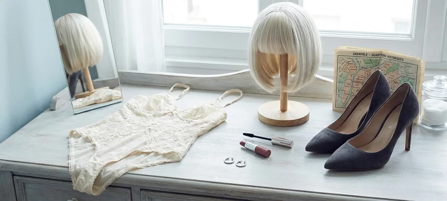 Garde-robe travesti pour Grenoble : escarpins, perruque et lingerie sur coiffeuse