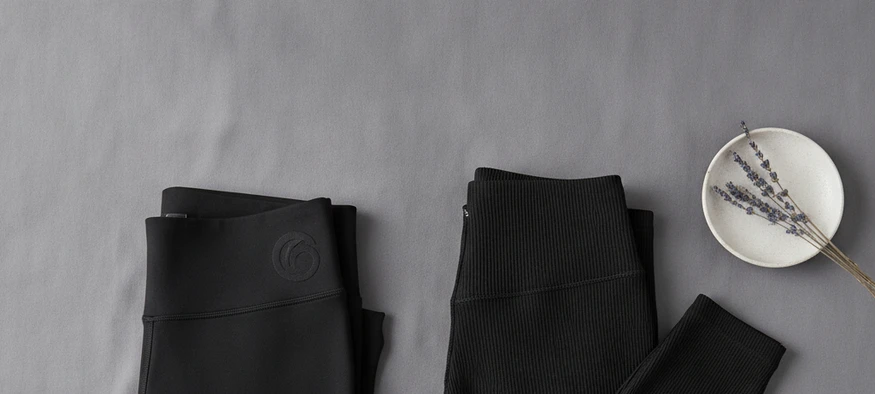 Deux leggings noirs moulants pour un legging travesti féminin, posés sur fond gris - Amenzia